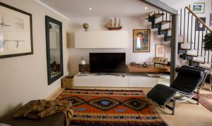 sala de estar con TV y escalera en Acacia Firenze - The Verde en Florence