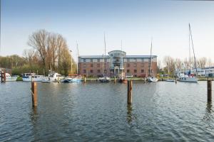 un puerto deportivo con barcos en el agua y un edificio en Jugendherberge Glückstadt en Glückstadt