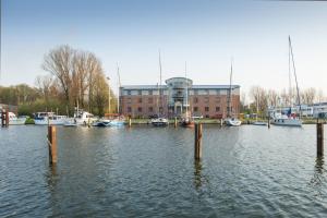 a marina with boats in the water and a building at Jugendherberge Glückstadt in Glückstadt