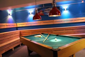 a pool table in a room with two cues on at Jugendherberge Glückstadt in Glückstadt