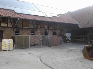 a building with a fence in front of a building at Kreuzdellenhof Ferienzimmer in Hembach