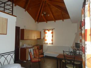 a kitchen and living room with a table and chairs at Vagionia Apartments in Ancient Epidauros