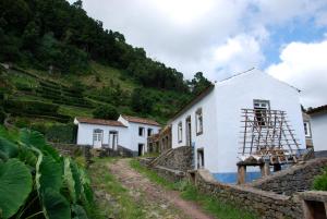a house with scaffolding on the side of a mountain at Aldeia do Sanguinho in Faial da Terra