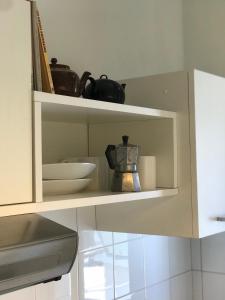 a kitchen cabinet with a shelf with items on it at La Casa di Zia Rita in Porto SantʼElpidio +30 photos