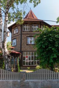 a large house with a fence in front of it at Guest House Blizhnie Dubki in Saint Petersburg