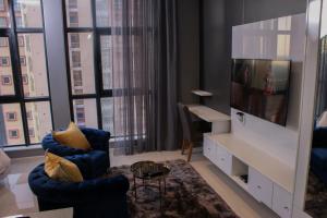 a living room with a tv and a blue chair at iTowers Studio Suite in Gaborone