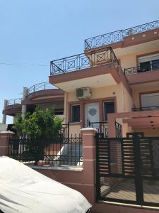a large house with a balcony and a fence at GIORGOS LUX APARTMENTS in Volos