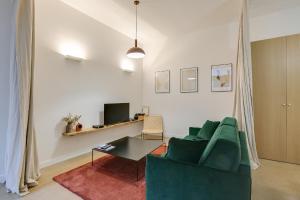 a living room with a green couch and a table at Joie Paris St Germain-des-Prés - Bon Marché in Paris