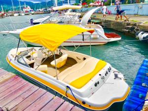a white boat with a yellow cover on a dock at Iveria in Batumi