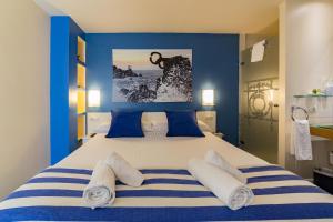 a bedroom with a large bed with blue walls at Ur-Alde in San Sebastián
