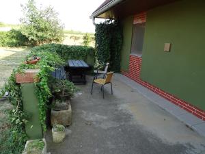 a patio with a table and chairs next to a green building at Penzion Pod Vápenkami in Strážnice