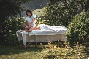a woman standing on a bed with a woman laying on it at Romantik Hotel Alpenblick Ferienschlössl in Hippach