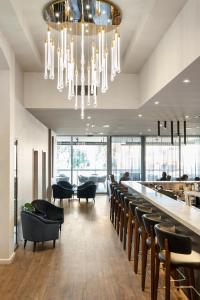 a restaurant with a bar with black chairs and a chandelier at Quality Hotel Wangaratta Gateway in Wangaratta