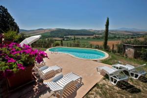 a swimming pool with a bunch of chairs and flowers at Agriturismo Podere Olivello in Val d'Orcia in Montalcino