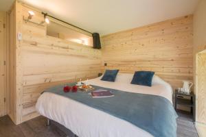 a bedroom with a large bed in a wooden wall at Résidence Grand Roc - Bruyères 119 in Chamonix-Mont-Blanc