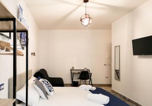 1 dormitorio con cama blanca y escritorio en Calenda Suite en Nápoles