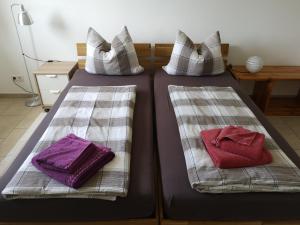 two beds with pillows and towels on them at Privatzimmer Sonne in Bad Säckingen