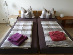 2 Betten mit Kissen und Handtüchern darauf in der Unterkunft Privatzimmer Sonne in Bad Säckingen