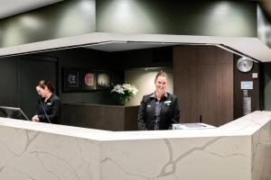 una mujer está parada frente a un espejo en Quality Hotel Wangaratta Gateway, en Wangaratta