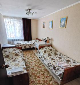 ジヴェエヴォにあるGuest House on Vostochnaya d 1Dのベッド2台と窓が備わるホテルルームです。
