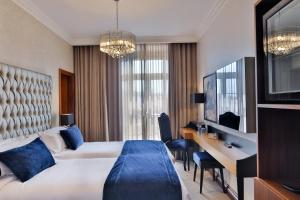 a hotel room with a large bed and a desk at Casual Belle Epoque Lisboa in Lisbon