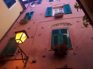 a pink building with colorful windows and a street light at CA AMABILE in Badalucco