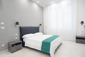 ein weißes Schlafzimmer mit einem Bett und einem Fenster in der Unterkunft Toledo in in Neapel