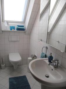 a white bathroom with a sink and a toilet at Weissewolke in Bad Fallingbostel