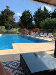 a swimming pool with lounge chairs and a swimming pool at Appartement Salvaterra in Sauveterre