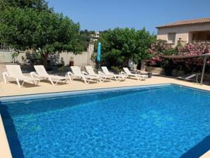 a swimming pool with lounge chairs and a swimming pool at Appartement Salvaterra in Sauveterre