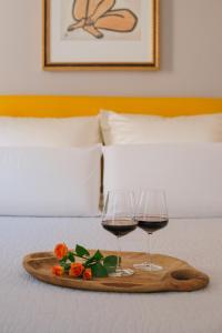 dwa kieliszki wina i kwiaty na tacy na łóżku w obiekcie Boutique B&B Vintage w mieście Palermo