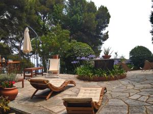 un patio con sillas, una mesa y una sombrilla en Torre Alpicella - Holiday Home, en Diano Marina