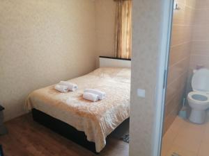 una camera da letto con un letto con due asciugamani sopra di Jeiran Japaridze's Guesthouse a Mestia