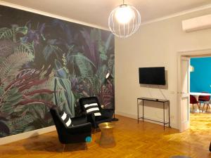 a living room with two chairs and a large wall mural at Jungle Suite in Naples