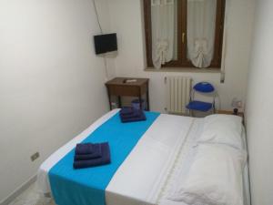 Un dormitorio con una cama azul y blanca y una silla en Home Sweet Home, en Matera