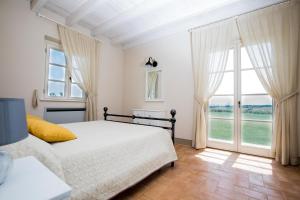 a bedroom with a bed and a large window at Agriturismo Colle Oliveto in Orbetello +73 photos