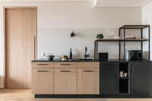 a kitchen with wooden cabinets and a black counter top at VillaVerde Aparthotel in Lagundo