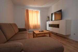 uma sala de estar com um sofá e uma televisão em Apartment Stuttgart Ost em Stuttgart