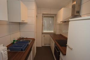 cocina con armarios blancos, fregadero y ventana en Apartment Stuttgart Ost, en Stuttgart
