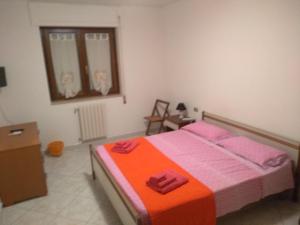 1 dormitorio con 1 cama con sábanas de color rosa y naranja en Home Sweet Home, en Matera
