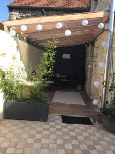 a patio with a wooden deck with a pergola at Gite L'Atelier in Bèze