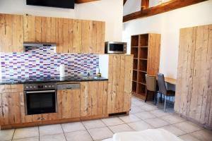 a kitchen with wooden cabinets and a stove at Apartment´s Marchtrenk in Marchtrenk