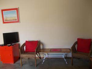 sala de estar con 2 sillas, mesa y TV en Huis KlipdriftSelf Catering &B&B en Hentiesbaai