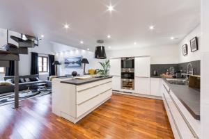 an open kitchen and living room with white cabinets at Les suites sainte claire in Annecy
