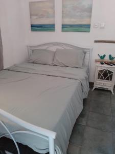a white bed in a room with a bed frame at Kmo Yam In The Love Garden in Kinneret