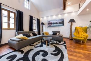 a living room with two couches and a rug at Les suites sainte claire in Annecy