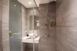 a bathroom with a glass shower with a sink and a toilet at ARK Hotel - Dongmen in Taipei +35 photos