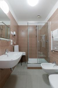 a bathroom with two sinks and a glass shower at Hotel Cristina in Naples