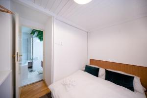 um quarto com uma cama branca e uma cabeceira em madeira em Luxurious Kafka family apt in Old Town em Praga