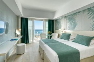 a hotel room with a bed and a view of the ocean at Ivi Mare - Designed for Adults by Louis Hotels in Paphos